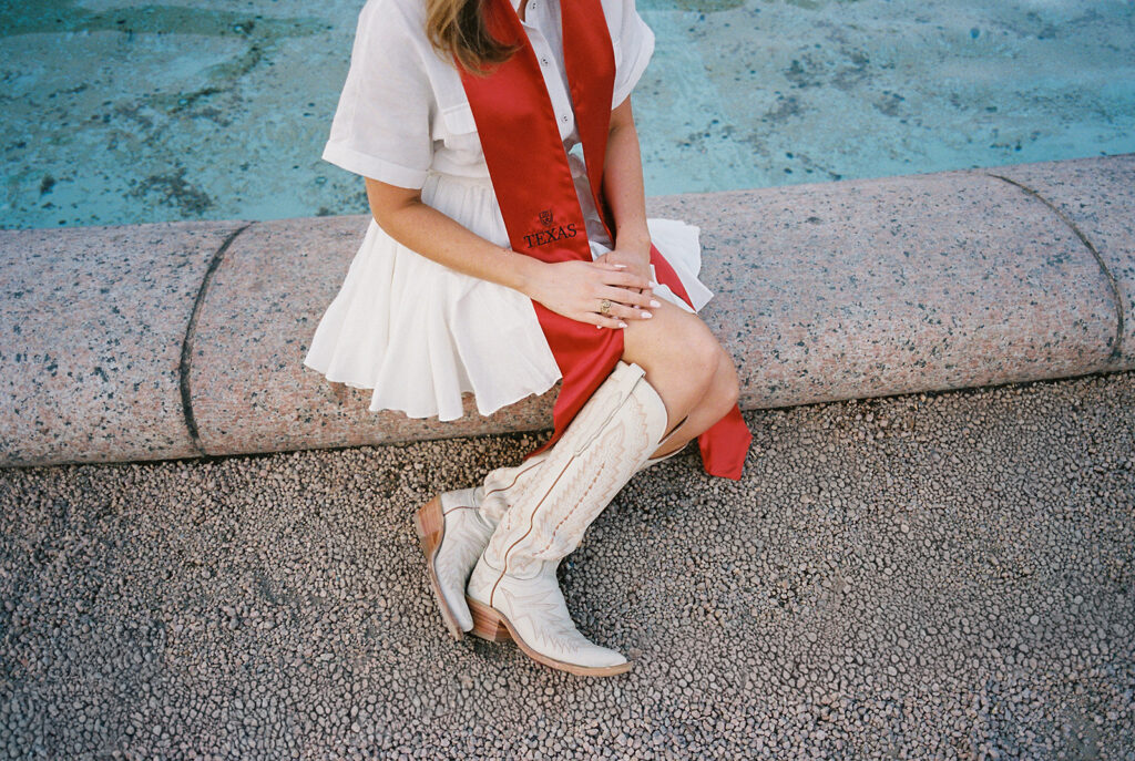 UT Austin grad photos at Littlefield Fountain during golden hour, capturing joyful senior portraits full of color and celebration.