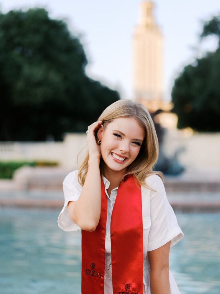 UT Austin grad photos at Littlefield Fountain during golden hour, capturing joyful senior portraits full of color and celebration on film