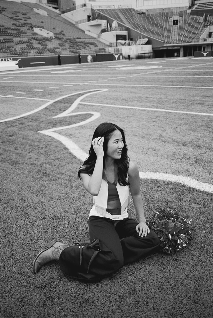 University of Texas senior in Texas Pom uniform during DKR stadium graduation session on film
