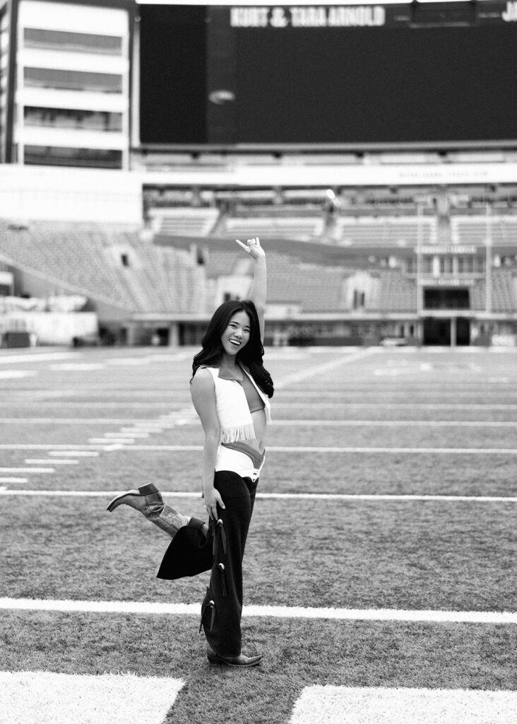 UT grad portraits at DKR Stadium with Texas Pom dancer on the field