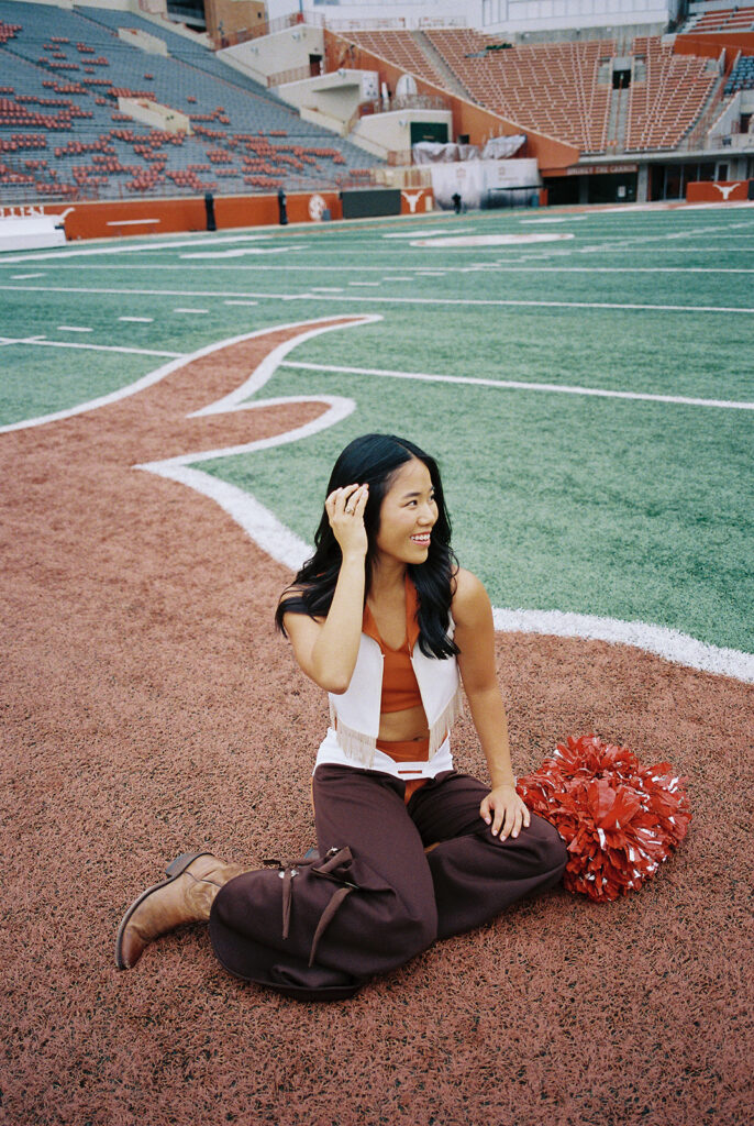 University of Texas senior in Texas Pom uniform during DKR stadium graduation session on film