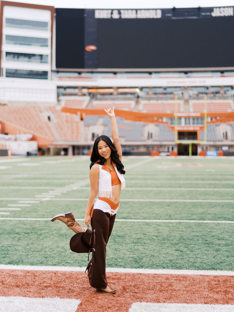 UT grad portraits at DKR Stadium with Texas Pom dancer on the field