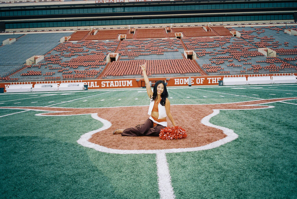 University of Texas senior in Texas Pom uniform during DKR stadium graduation session on film
