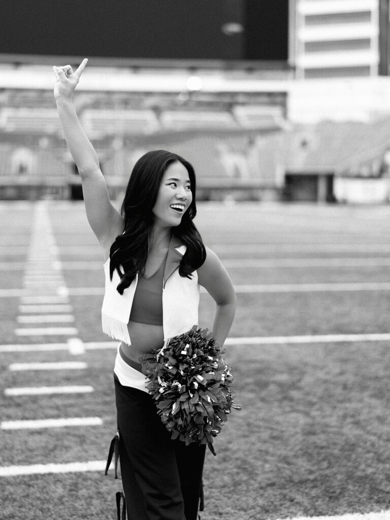 UT grad portraits at DKR Stadium with Texas Pom dancer on the field