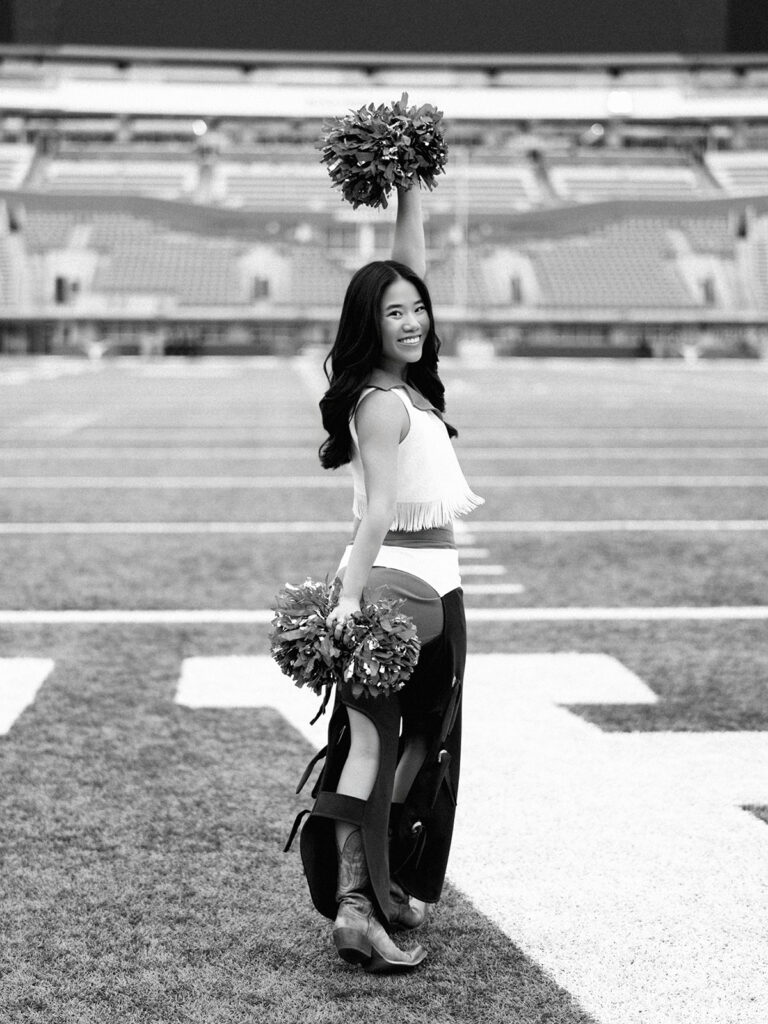UT grad portraits at DKR Stadium with Texas Pom dancer on the field