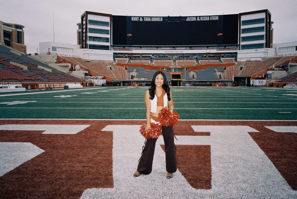 University of Texas senior in Texas Pom uniform during DKR stadium graduation session on film