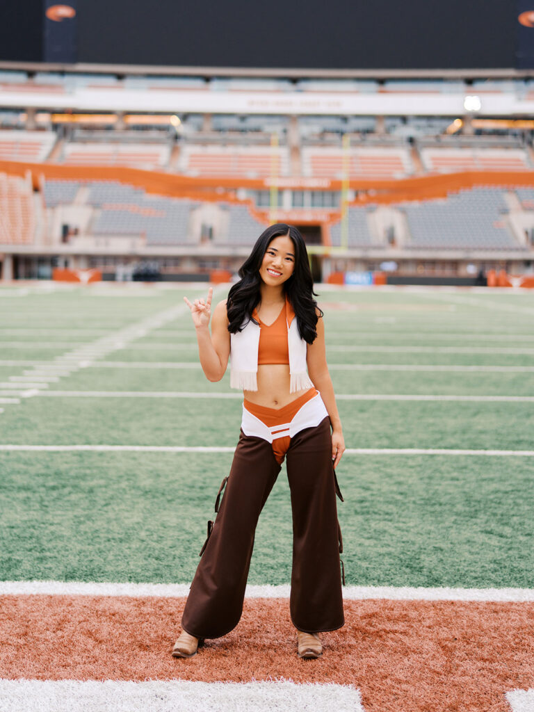 University of Texas senior in Texas Pom uniform during DKR stadium graduation session