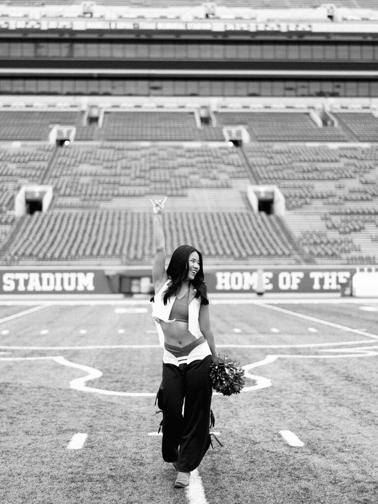 UT grad portraits at DKR Stadium with Texas Pom dancer on the field