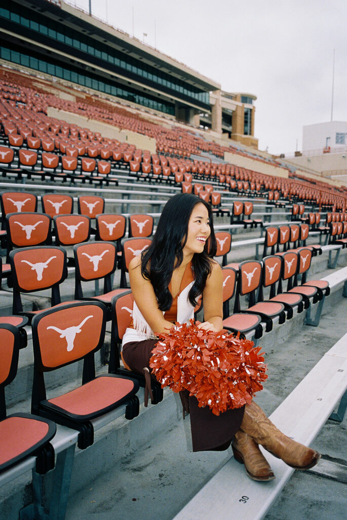University of Texas senior in Texas Pom uniform during DKR stadium graduation session on film