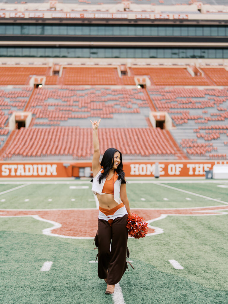 UT grad portraits at DKR Stadium with Texas Pom dancer on the field