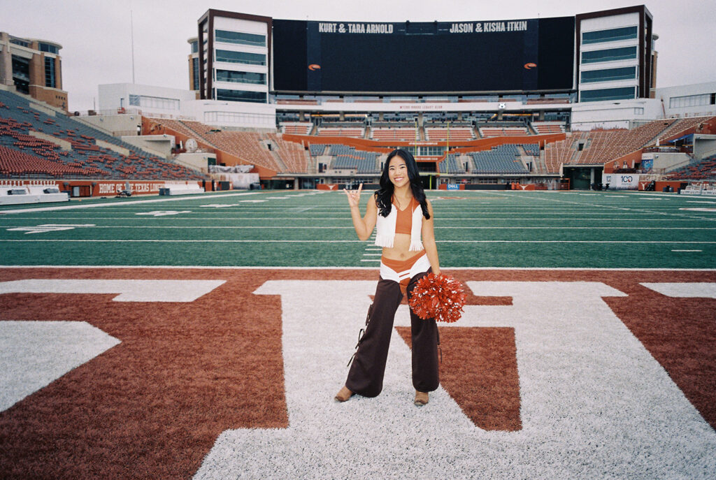 University of Texas senior in Texas Pom uniform during DKR stadium graduation session on film