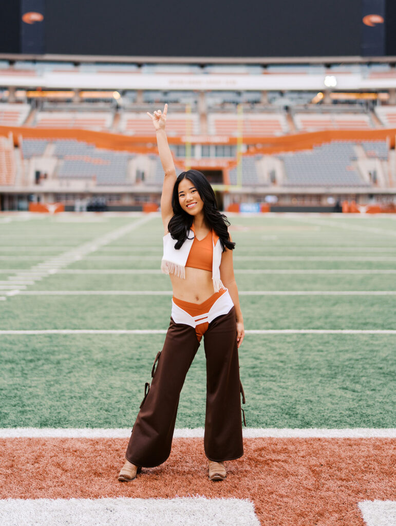 University of Texas senior in Texas Pom uniform during DKR stadium graduation session