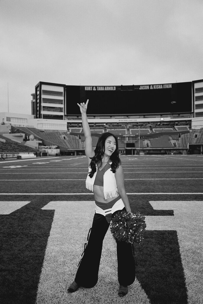 University of Texas senior in Texas Pom uniform during DKR stadium graduation session on film