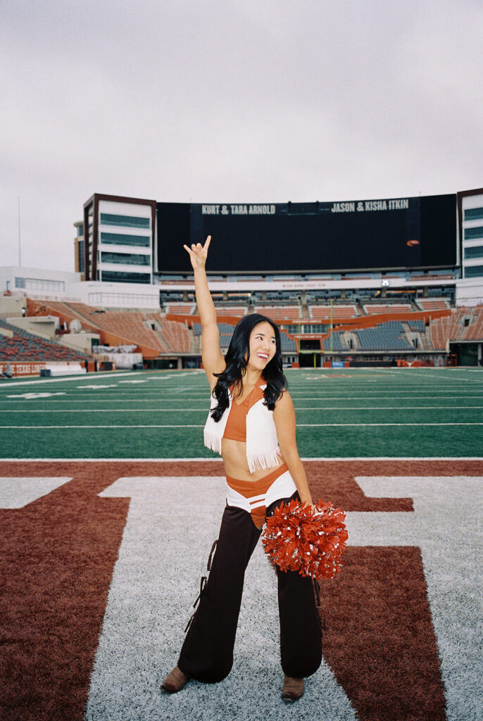 University of Texas senior in Texas Pom uniform during DKR stadium graduation session on film
