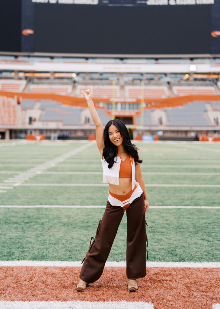 University of Texas senior in Texas Pom uniform during DKR stadium graduation session