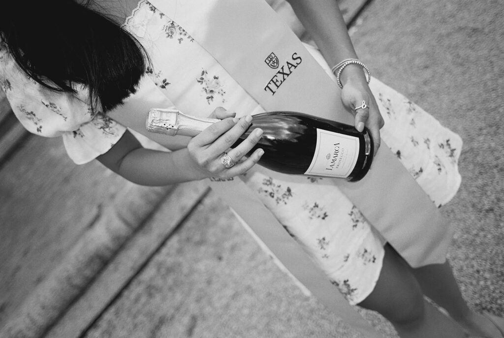 Champagne pop photo in the UT fountain during senior session on film