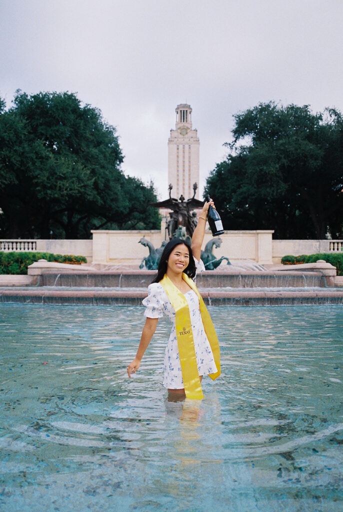 Champagne pop photo in the UT fountain during senior session on film