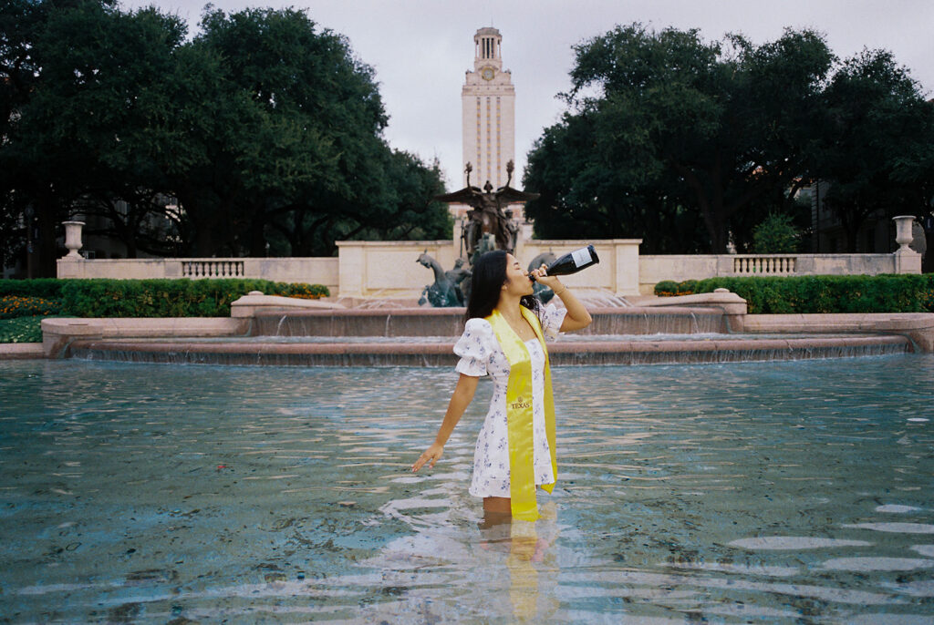 Champagne pop photo in the UT fountain during senior session on film