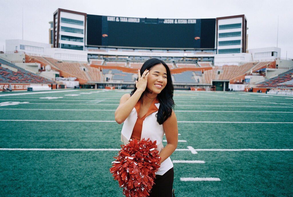 University of Texas senior in Texas Pom uniform during DKR stadium graduation session on film
