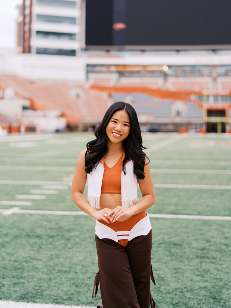 University of Texas senior in Texas Pom uniform during DKR stadium graduation session