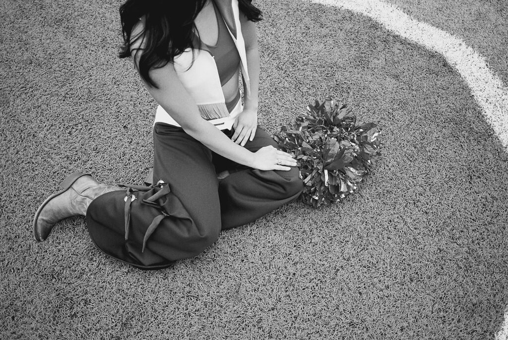 University of Texas senior in Texas Pom uniform during DKR stadium graduation session on film
