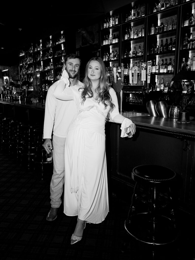 Chris and Reagan laughing at the bar during their Seven Grand Austin engagement session