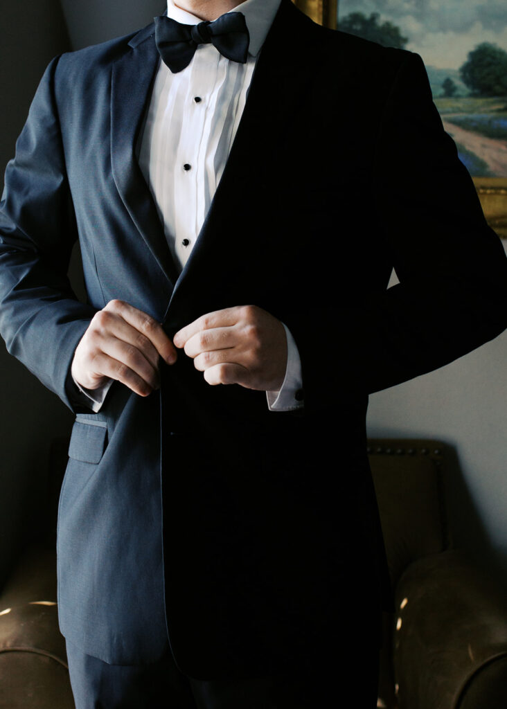 Groom adjusting tie before first look on winter wedding day