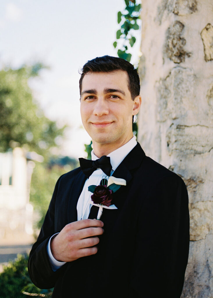 Groom adjusting tie before first look on winter wedding day
