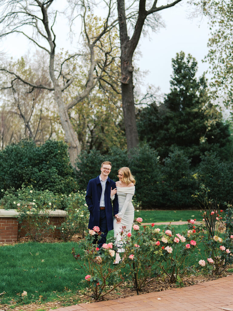 Sierra and Liam walking together during their Dallas Arboretum engagement photos