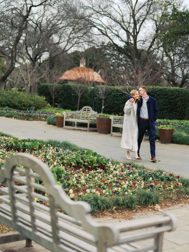 Sierra and Liam walking together during their Dallas Arboretum engagement photos