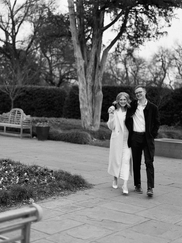 Sierra and Liam walking together during their Dallas Arboretum engagement photos