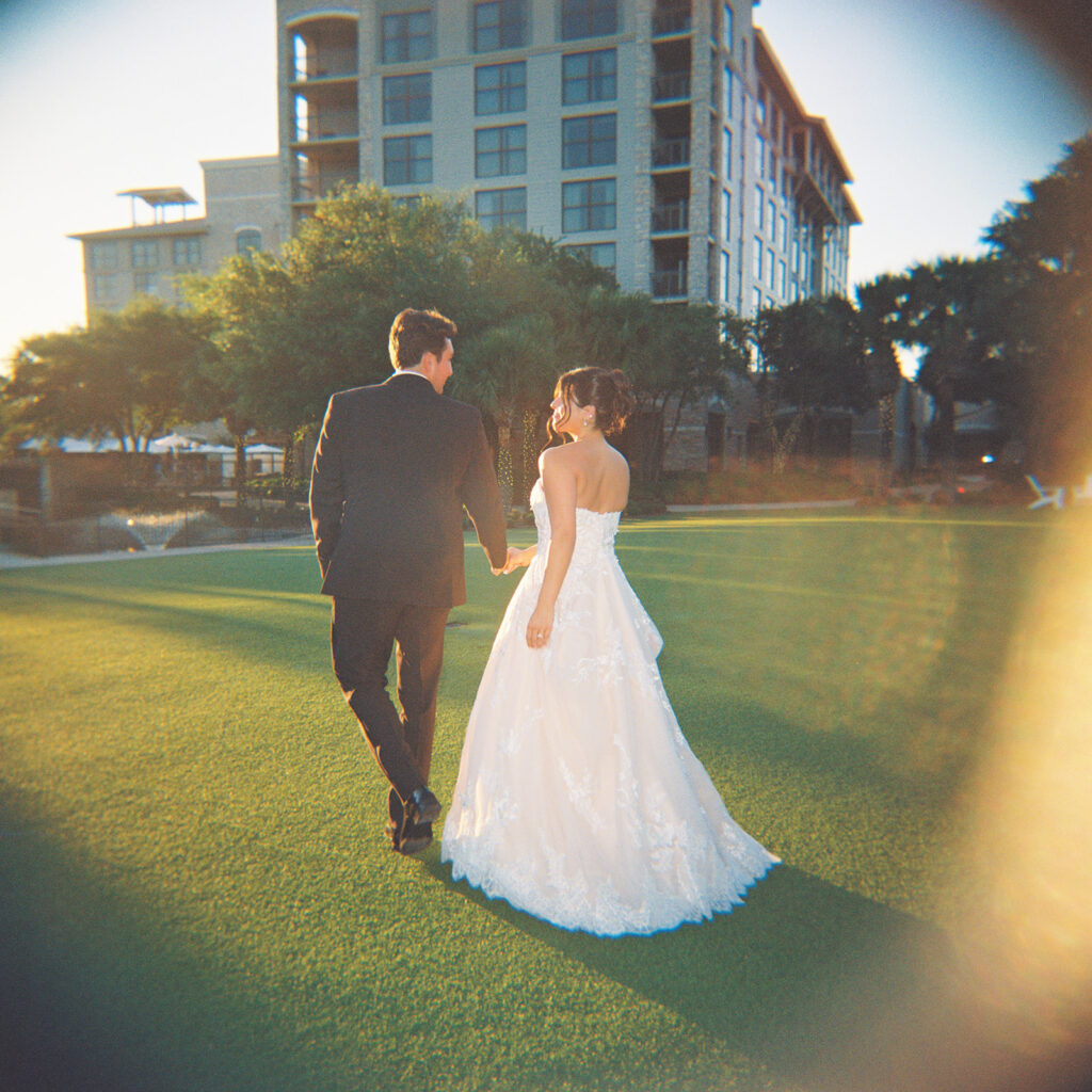 Bride and groom sharing romantic wedding portraits at Horseshoe Bay Resort surrounded by sunshine and stunning Lake LBJ scenery.