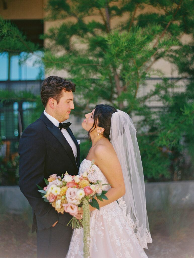 Bride and groom sharing romantic wedding portraits at Horseshoe Bay Resort surrounded by sunshine and stunning Lake LBJ scenery.