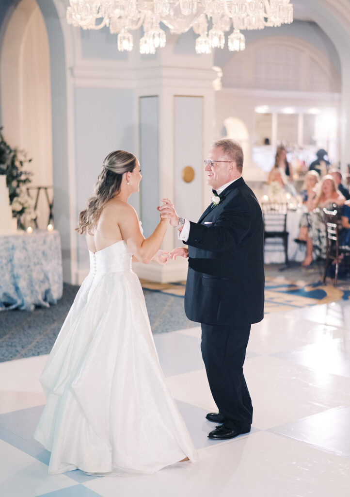 Elegant wedding reception at the Grand Galvez in Galveston, Texas featuring lush florals, soft blue details, and joyful celebration