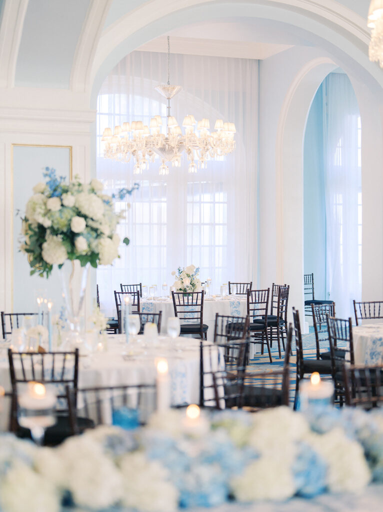 Elegant wedding reception at the Grand Galvez in Galveston, Texas featuring lush florals, soft blue details, and joyful celebration