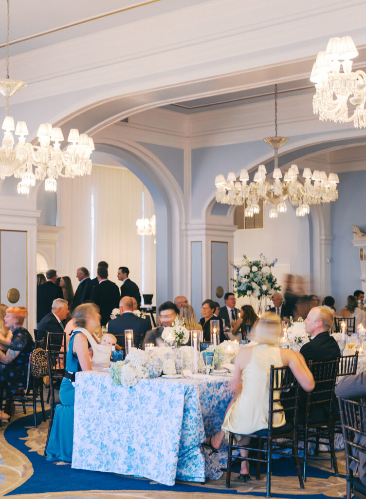Elegant wedding reception at the Grand Galvez in Galveston, Texas featuring lush florals, soft blue details, and joyful celebration